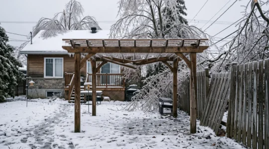 Une pergola et une clôture en bois couvertes de verglas après une tempête de glace dans une cour résidentielle au Québec.